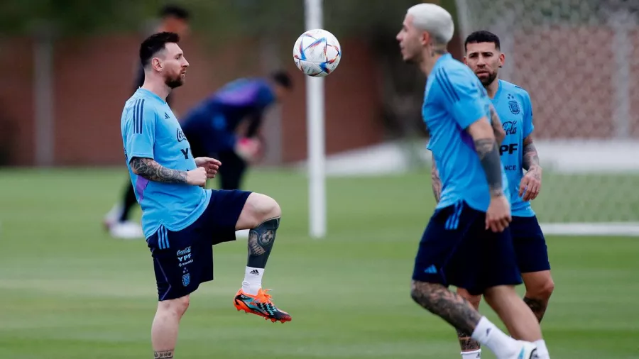 Lionel Messi tocando balón junto a Enzo Fernández y Nicolás Otamendi